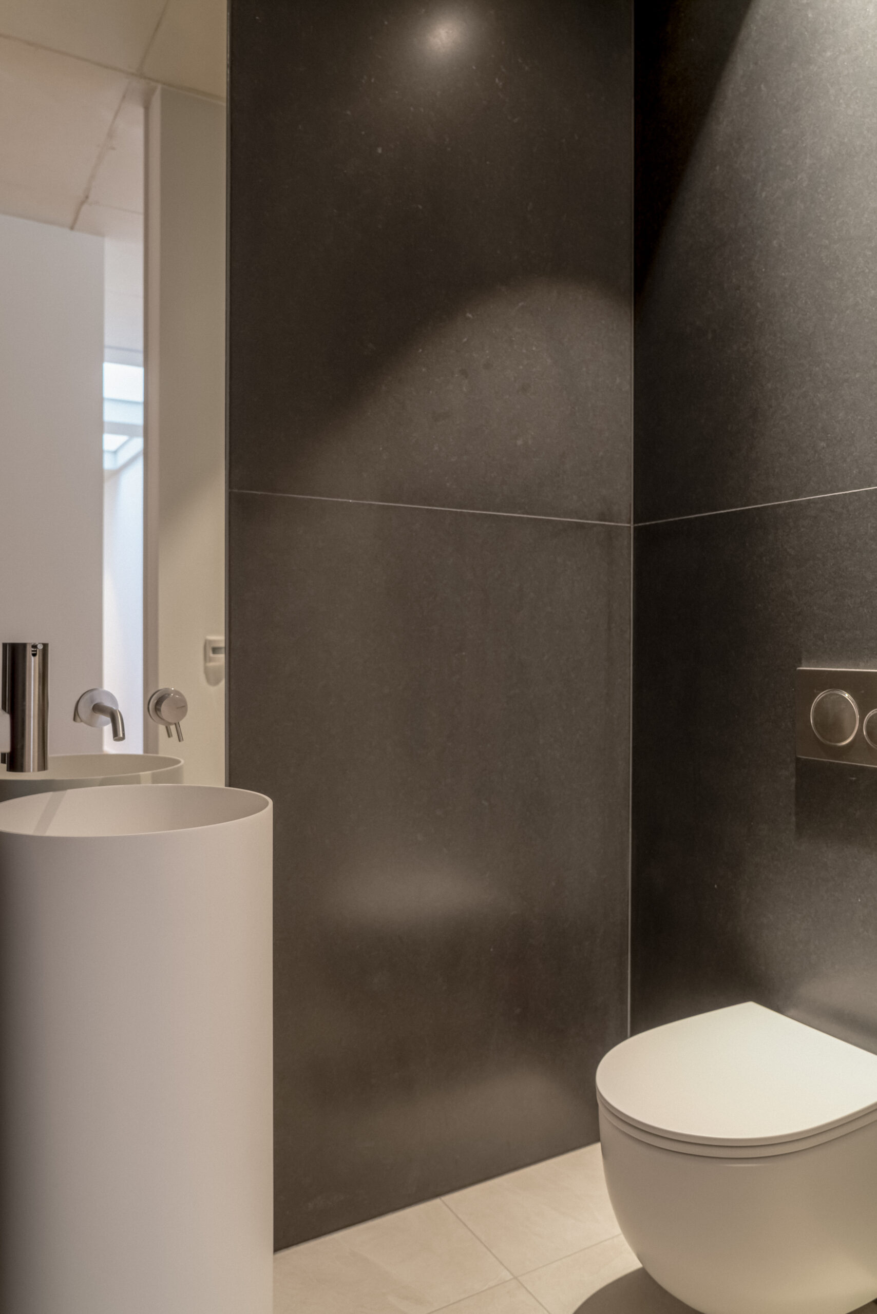 Gäste-WC mit Standwaschbecken und Granitsteinwand in der Penthousewohnung MIA in Michelau.